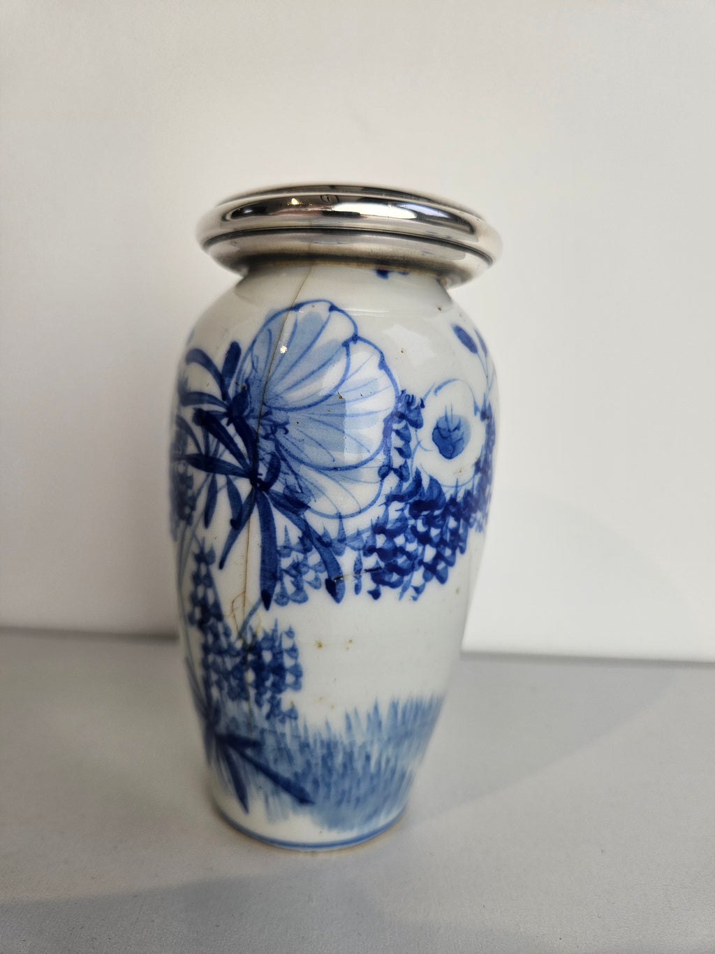 Antiek porseleinen vaasje met zilveren rand – blauw-wit decor