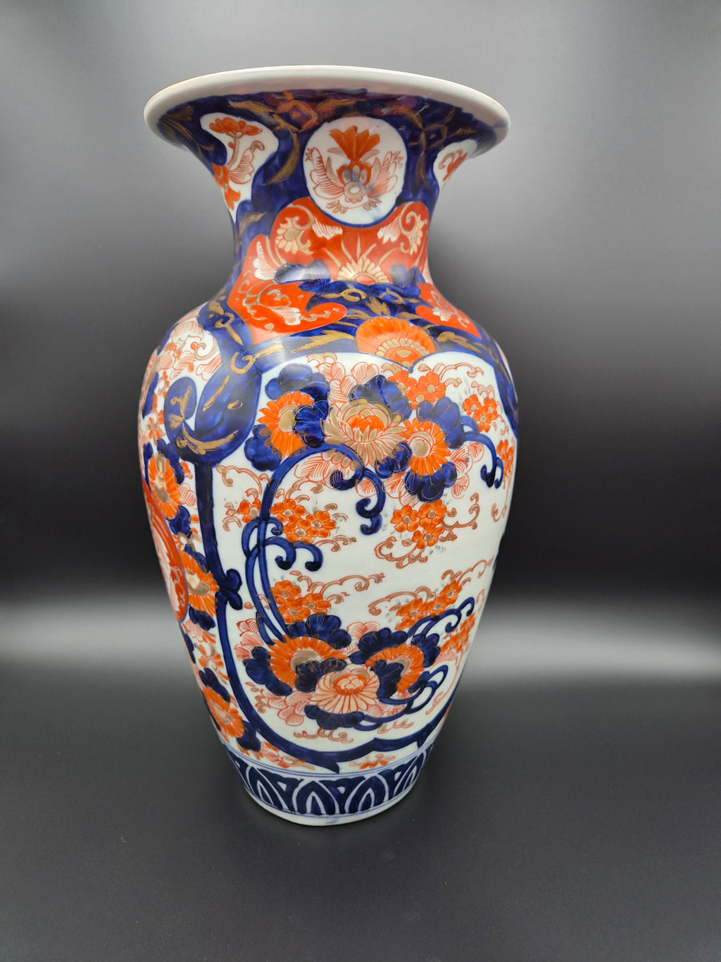 Porseleinen vaas met symmetrisch Imari-motief in oranje, blauw en wit, staand.