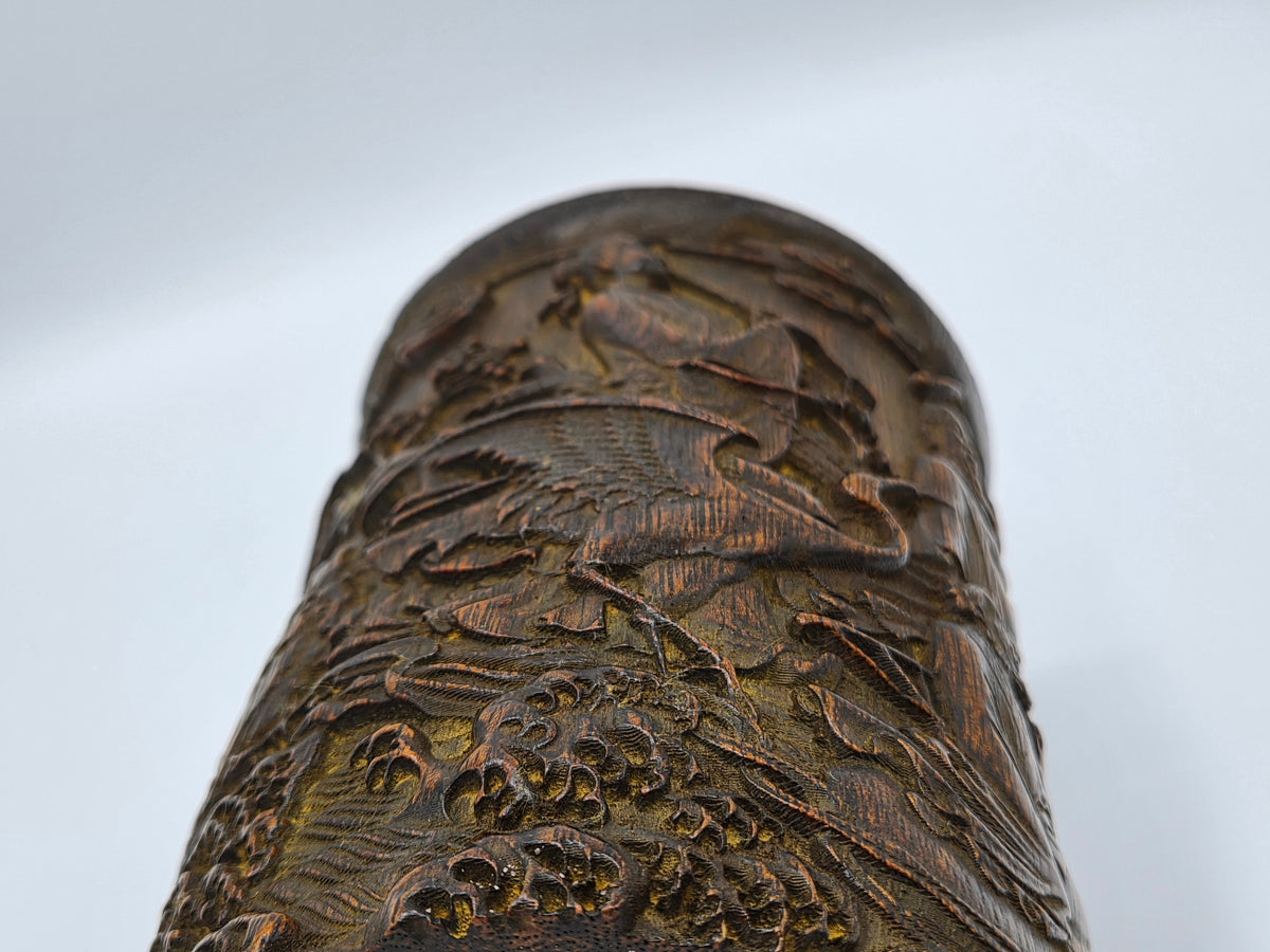 Detail van donkerbruine penseelpot met reliëfsculptuur en golvende patroonstreken