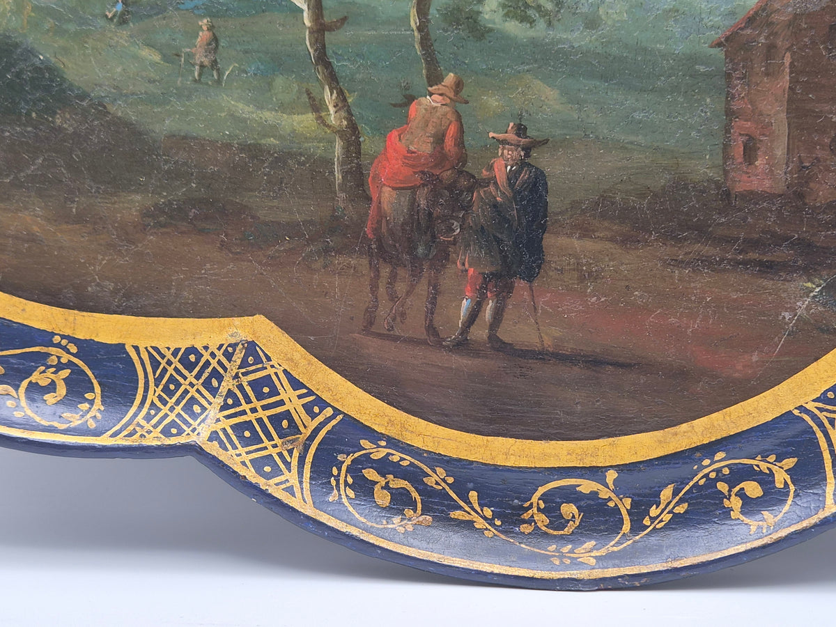 Geschulpte rand met goudornamenten op donkerblauwe dienbladzijde met landschap