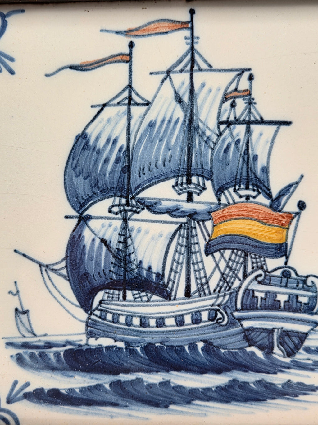 Close-up wandtegel: zeilschip met blauwe zeilen en oranje vlag in decoratie