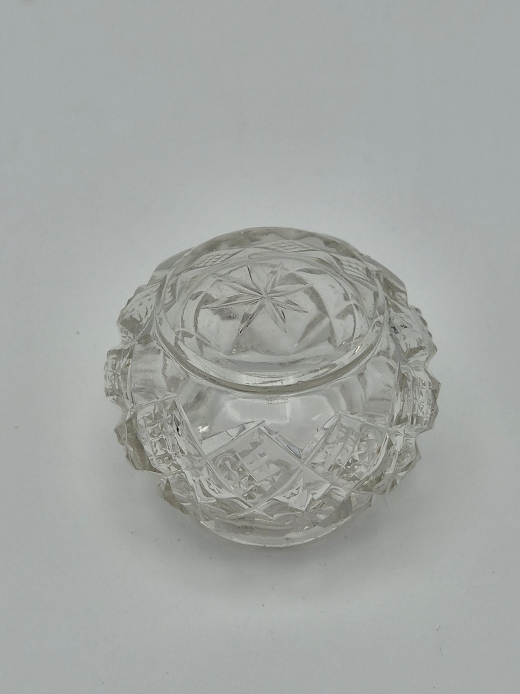 Onderkant van een rond potje van geslepen glas