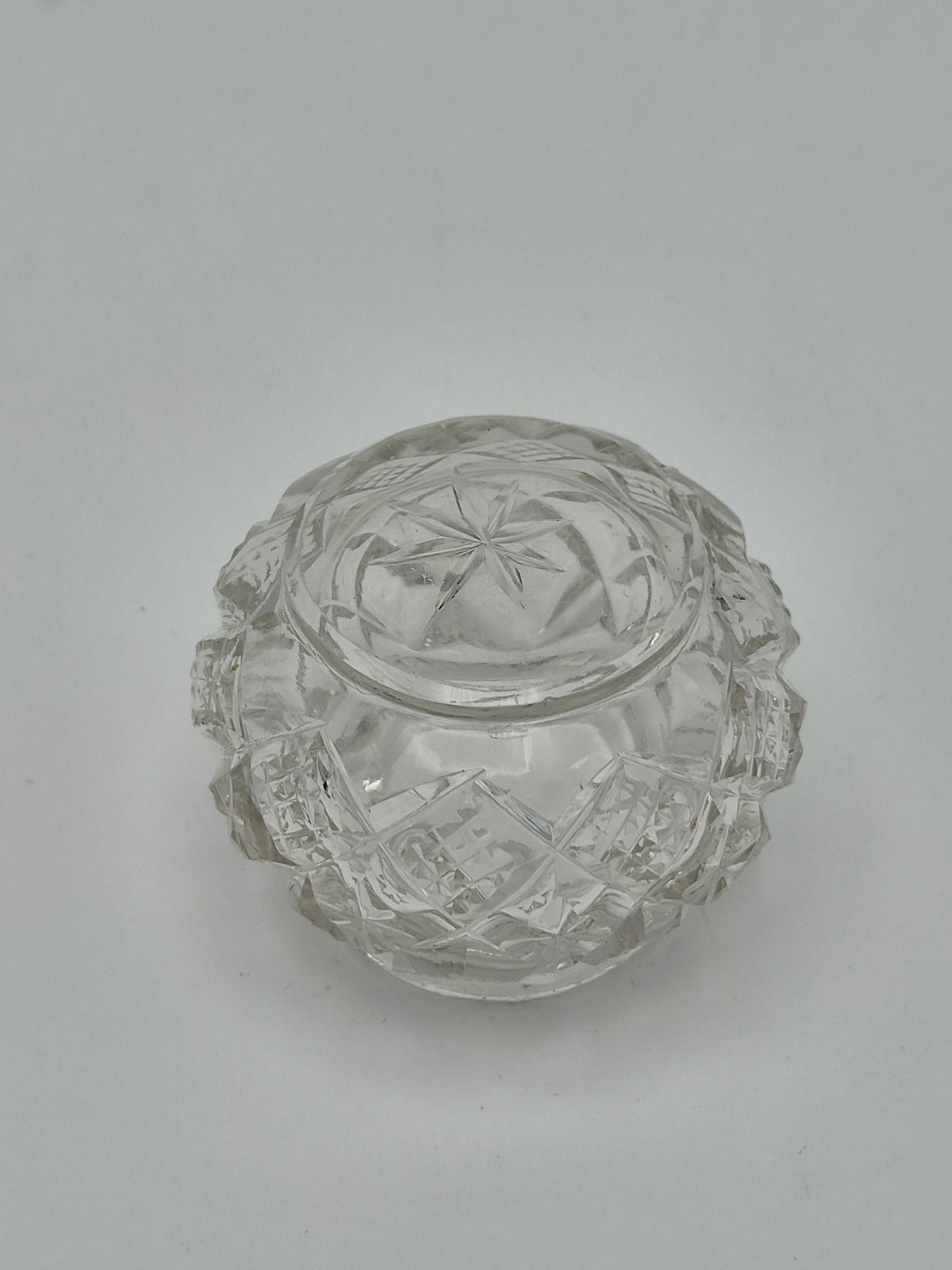 Onderkant van een rond potje van geslepen glas